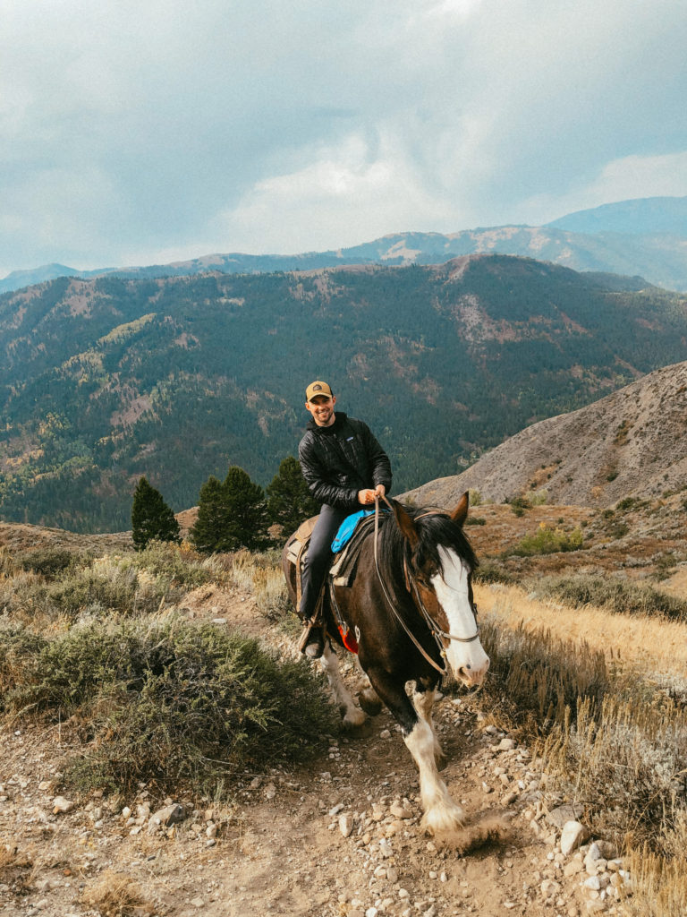 Sam riding on a horse up a mountain out West.