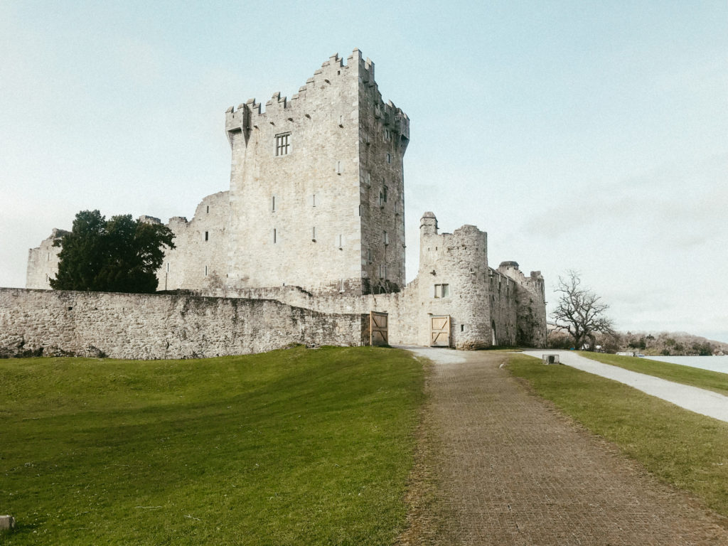 An Irish castle with greenery surrounding its landscape.