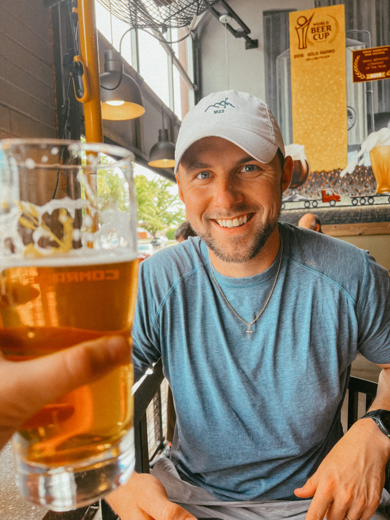 Sam with a beer at Comrade Brewing Company, one of the best breweries in Denver, Colorado!