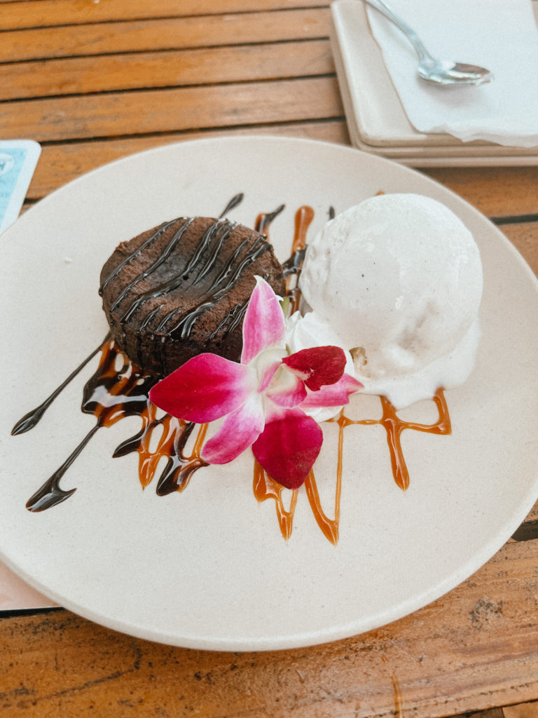 A lava cake served with ice cream and a flower.