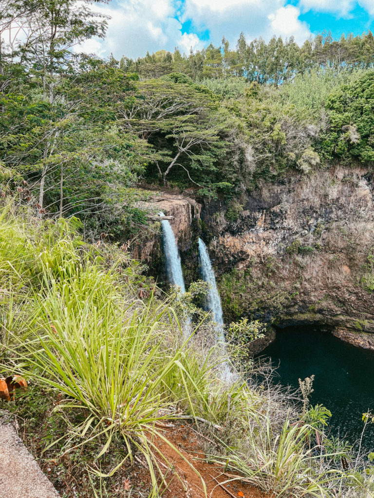 Two waterfalls pouring water into a pond on the best 7 day Kauai itinerary!