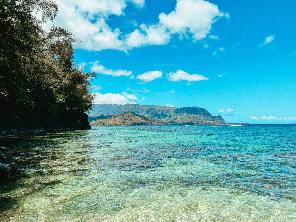 A beach in Kauai with crystal blue water.
