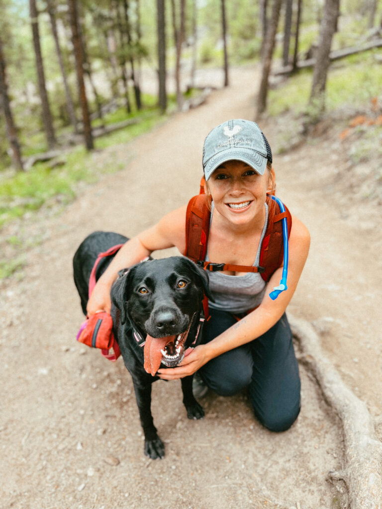 Abby hiking with Clover wearing a pair of the best hiking socks to prevent blisters!