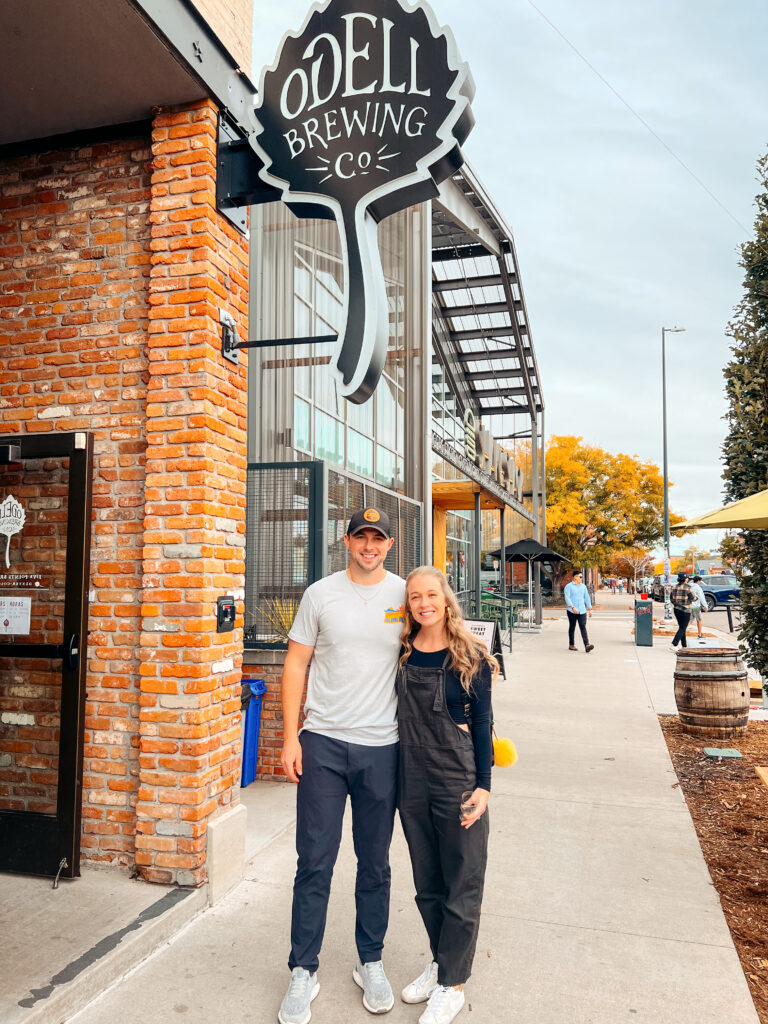 Abby and Sam smiling outside of Odell Brewing Company on the best microbrewery tour in Denver.
