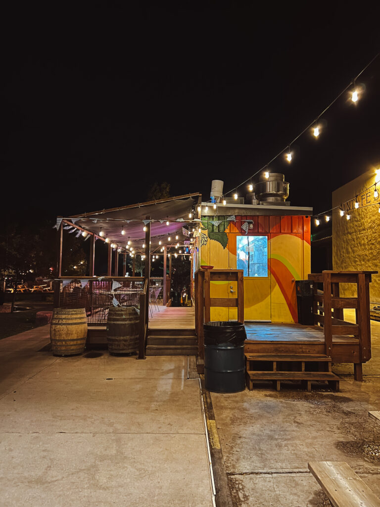 A brewery in Santa Fe, New Mexico with string lights and a colorful food truck.