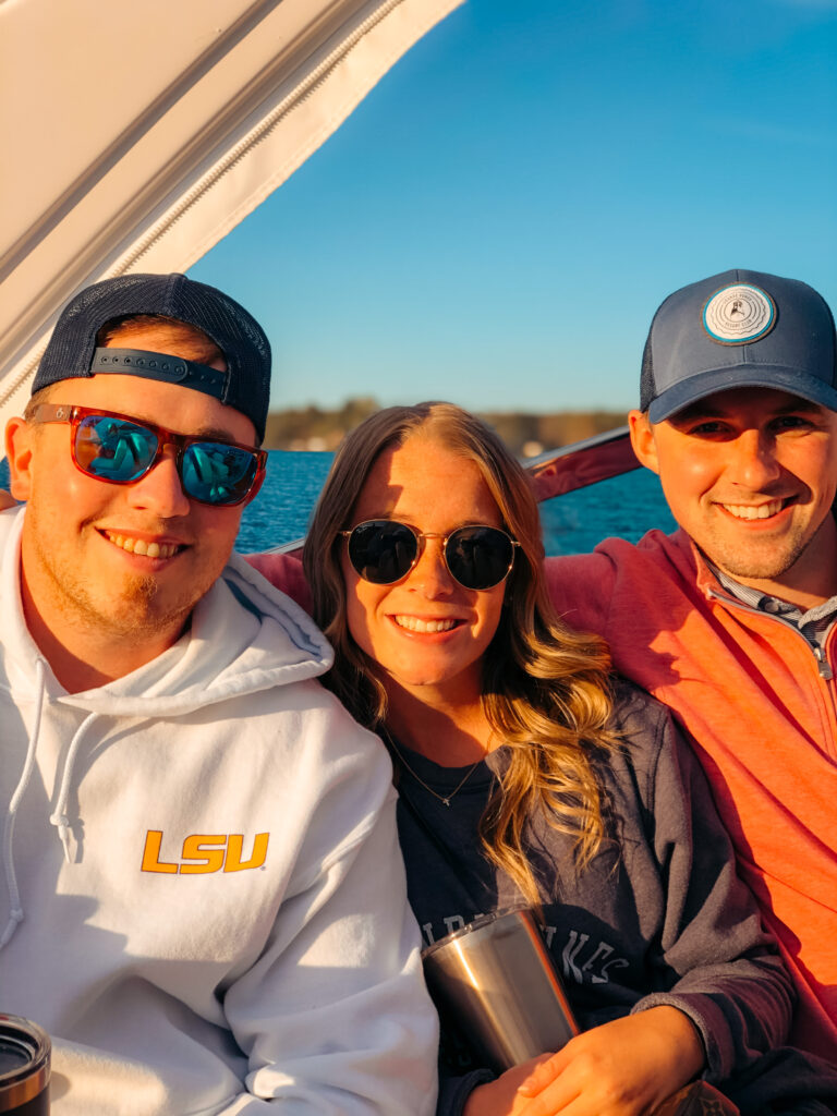 Colton, Abby, and Sam smiling on a boat on Smith Mountain Lake. 