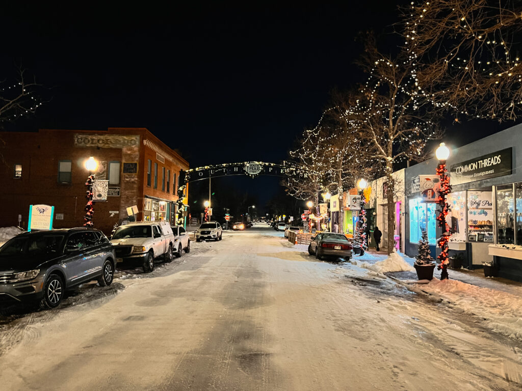 A Colorado street covered in snow lit up for the holiday season.