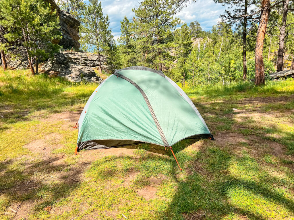 The best tent for hot weather camping pitched on grass with trees in the background.