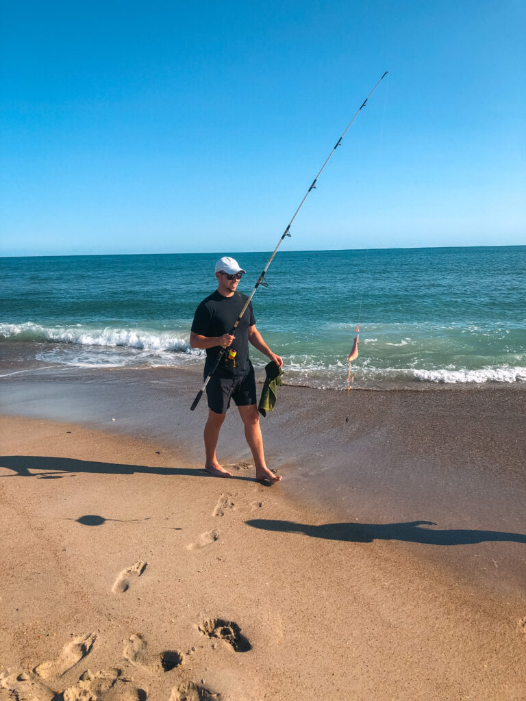 Sam walking on the beach with his surf fishing rod.