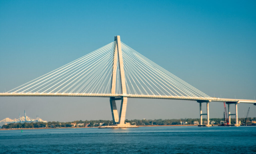 A popular bridge over the water in Charleston with blue skies in the background.