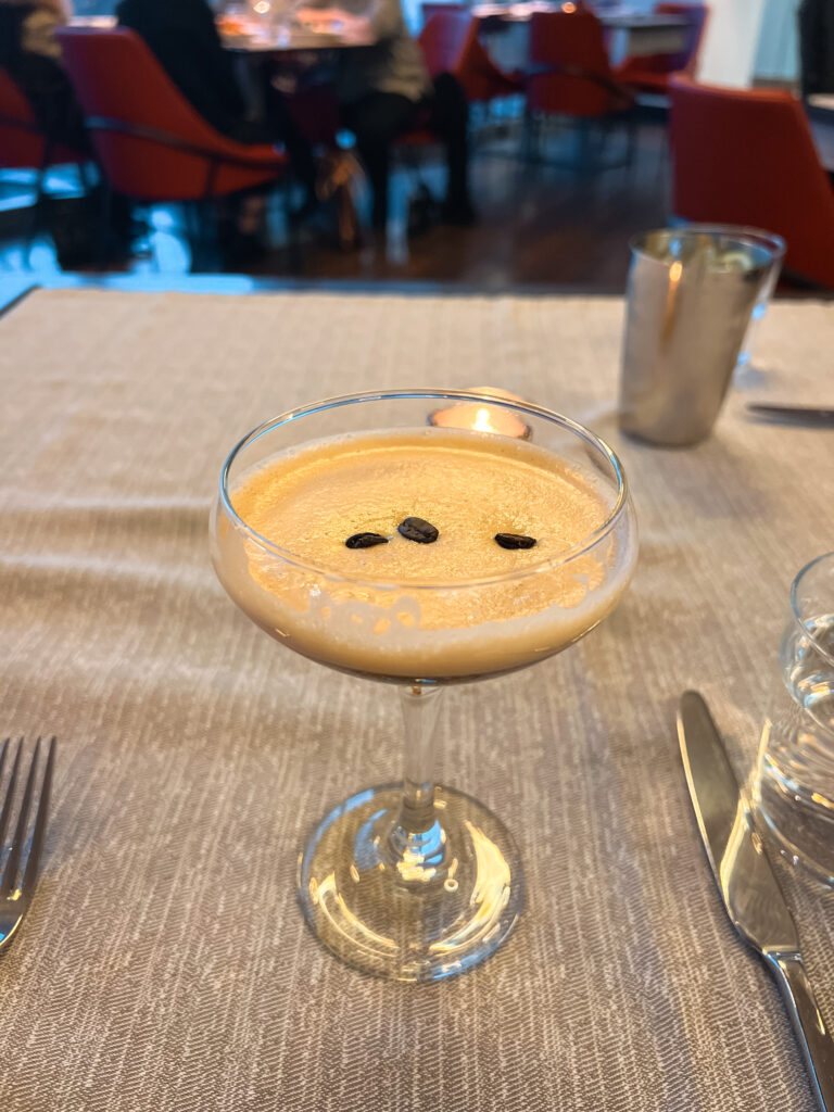 An espresso martini served with three coffee beans.