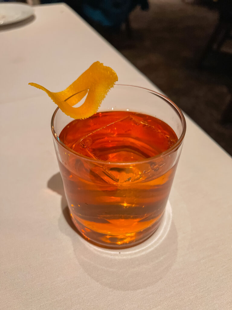 A unique cocktail served with an orange peel.