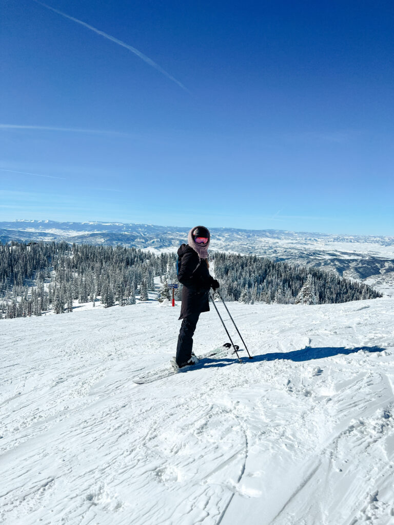Abby skiing in Steamboat Springs with blue skies in the background.