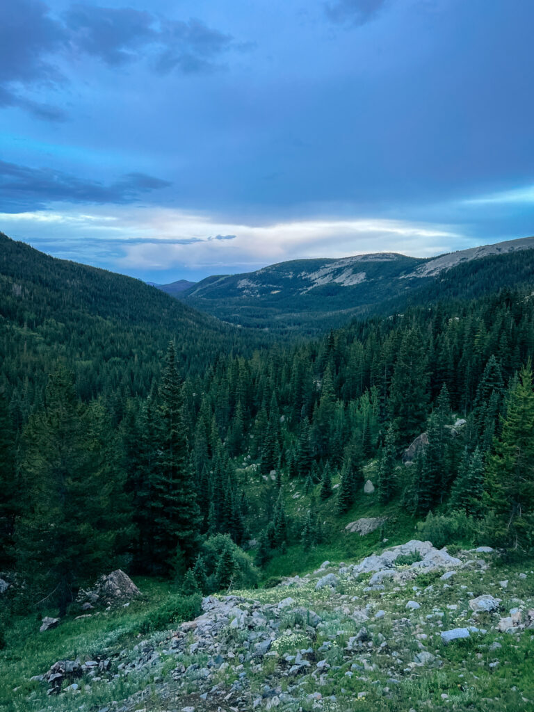 Mountain views with green trees surrounding them as Abby and Sam use some of the best hiking flashlights to navigate around the Colorado mountains.