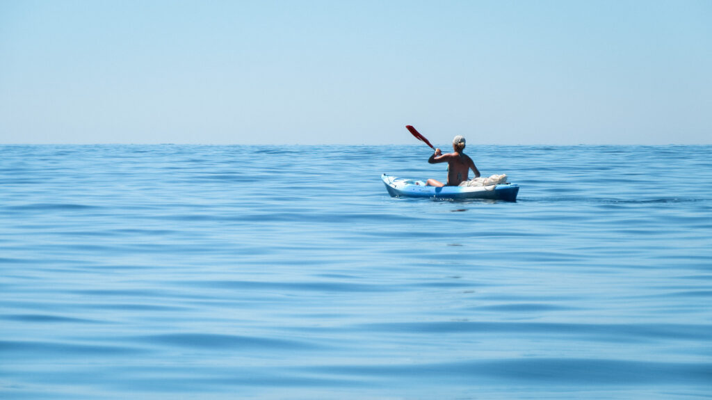 A person kayaking on the open water.
