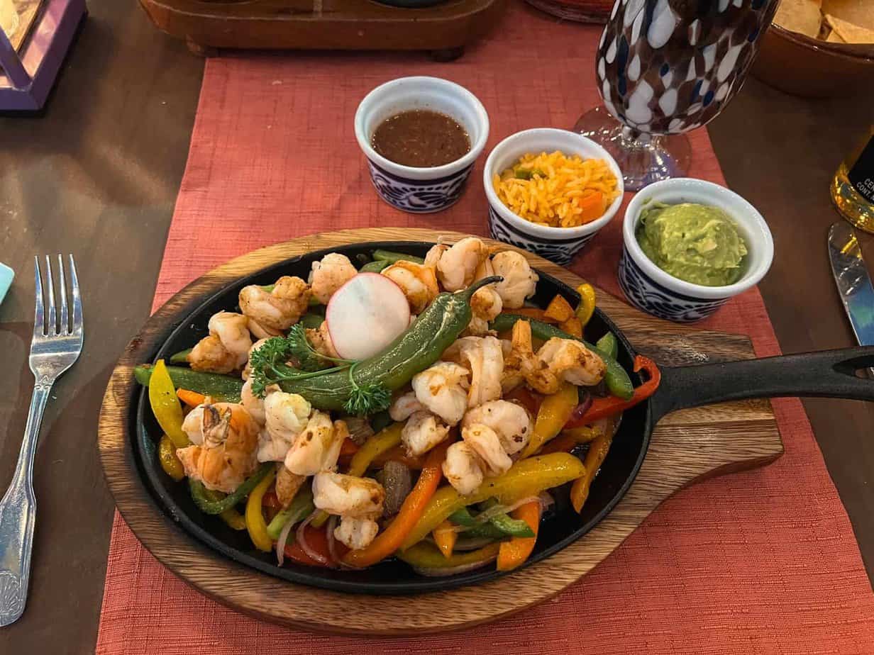 Sizzling fajitas served up on a warm cast iron pan.