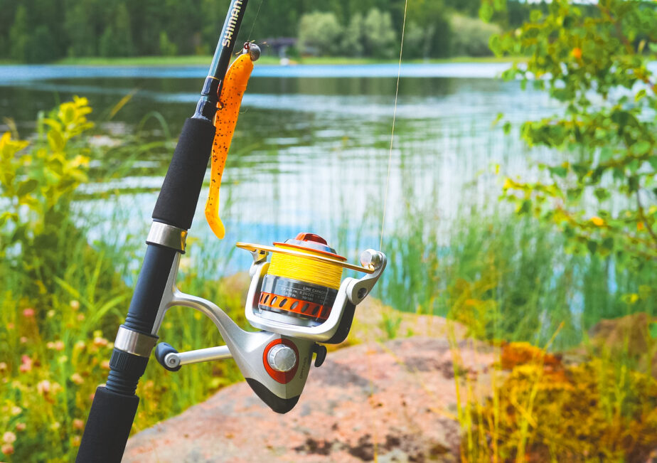 A surf fishing reel set up and ready to use with water in the background. 