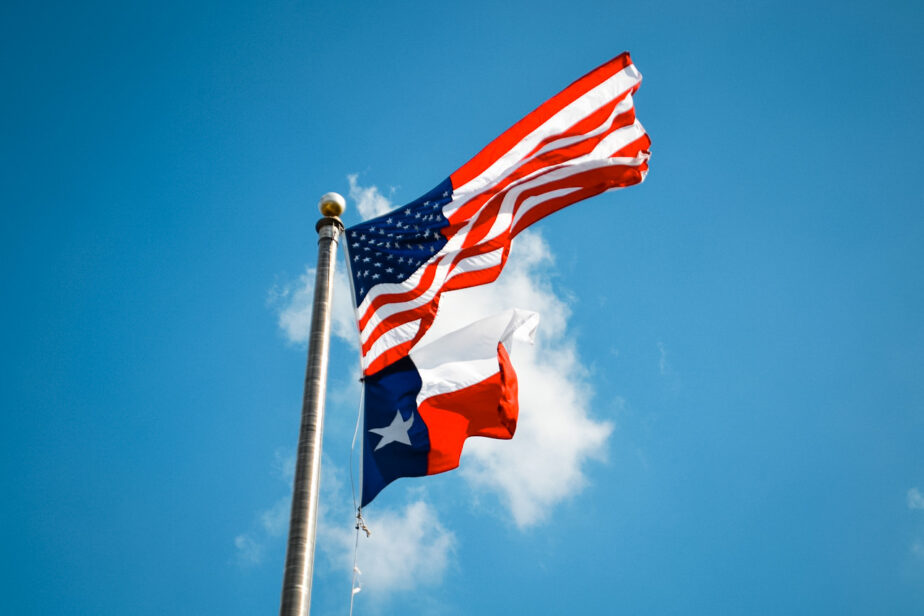 The American Flag and the Texas flag flying in the wind.