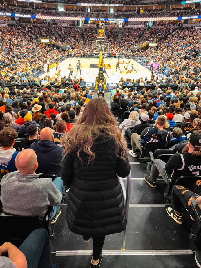 Abby walking down stairs at a Denver Nuggets game at Ball Arena.