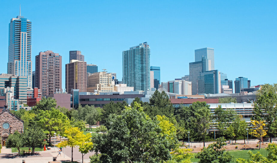 A skyline view of Denver with some greenery.