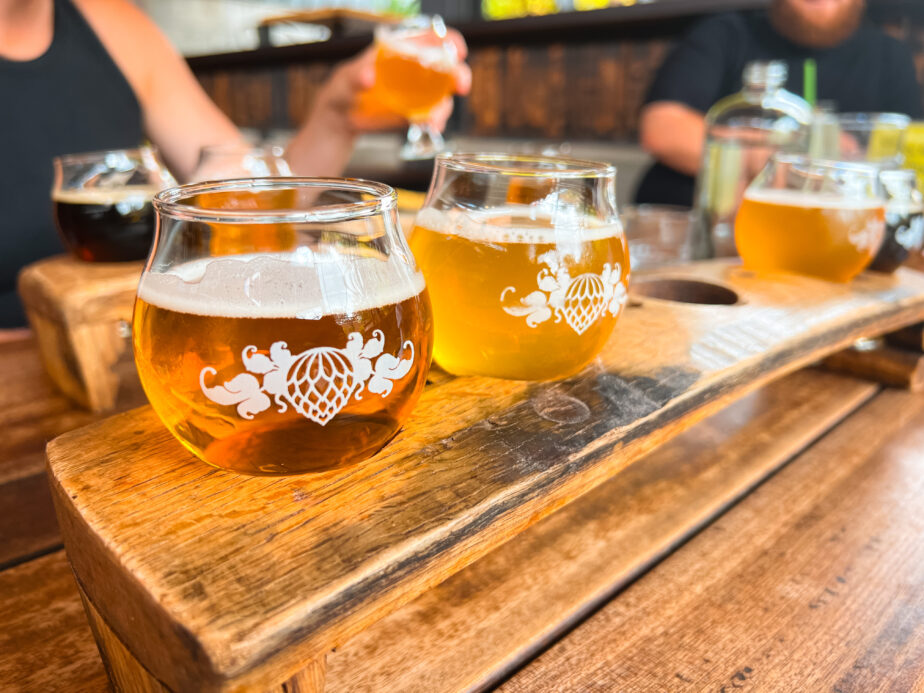 A flight of craft beer served on a wooden table.