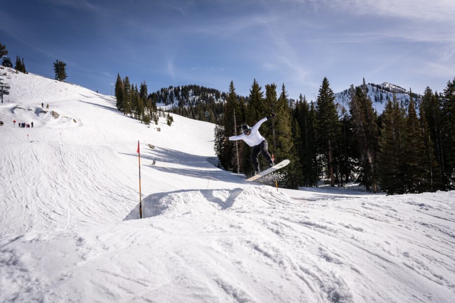 A snowboarder jumping on a ski slope.