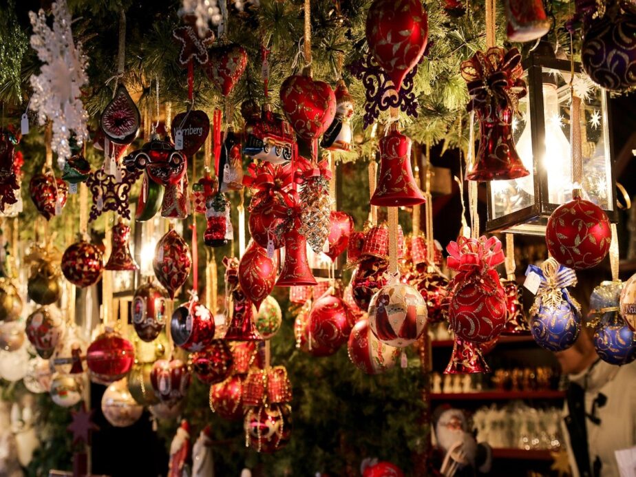 Christmas ornaments and decor hanging up at a market.