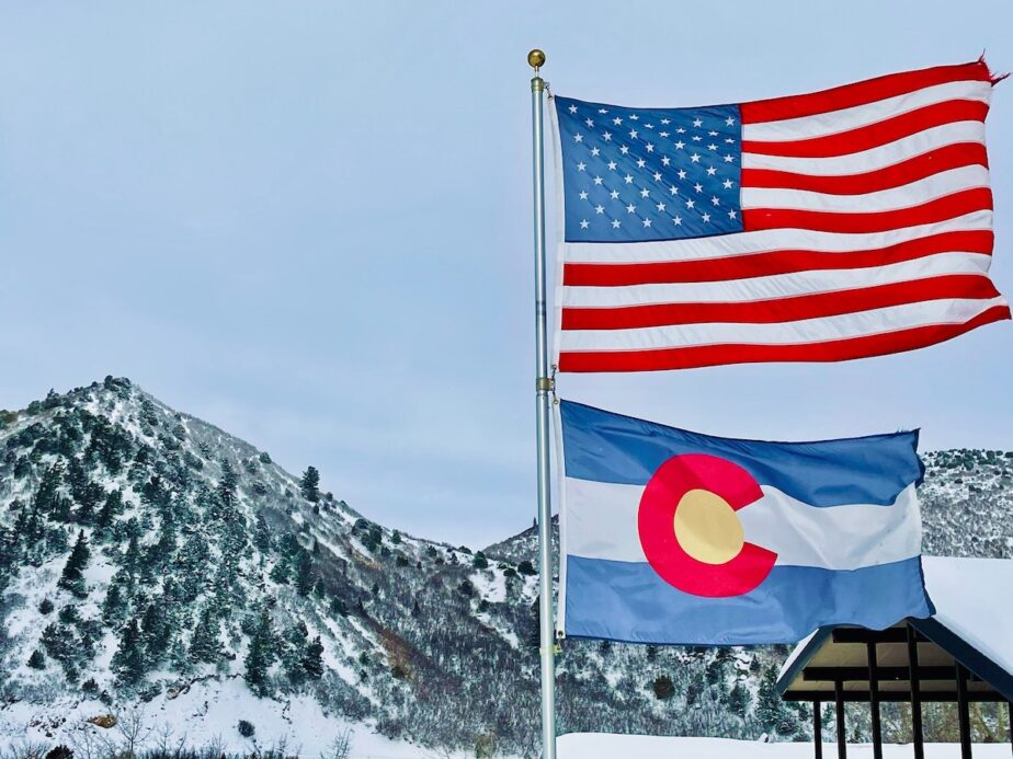 Glenwood Springs in winter with the American flag and the Colorado flag.