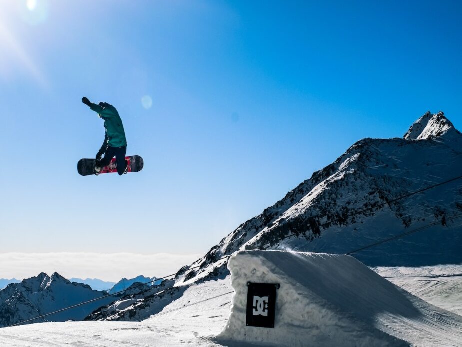 A snowboarder jumping on the slopes.
