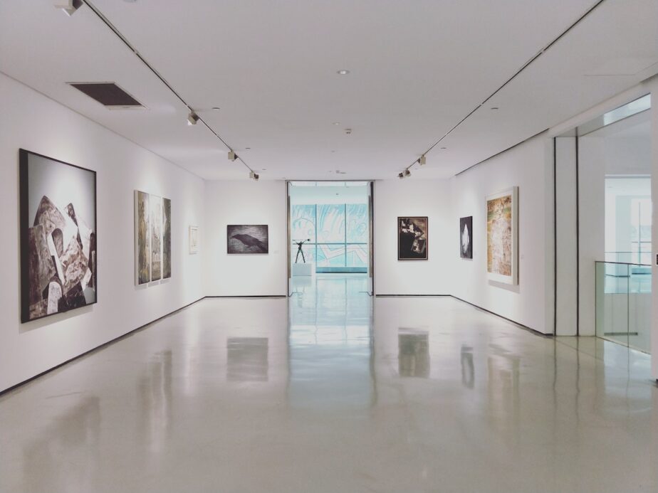 An art gallery with white walls and art pieces.