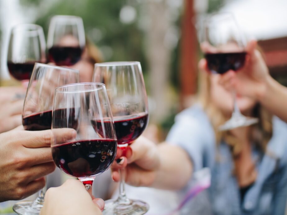 A group of friends cheersing their red wines.