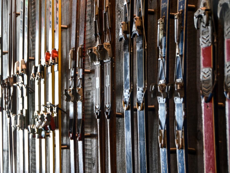 Multiple skis hanging up on a wall.
