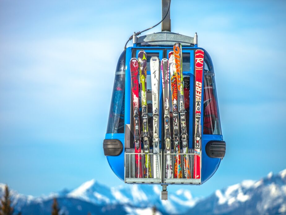 A gondola with several skis on the outside.