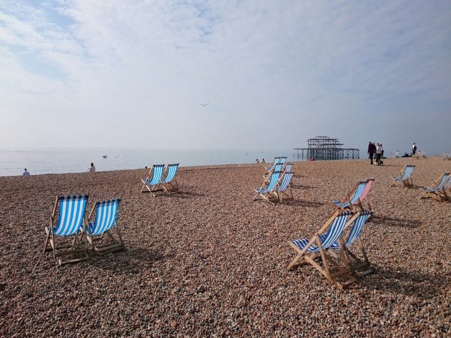 Brighton Beach with blue and white striped chair sitting out looking at the water.