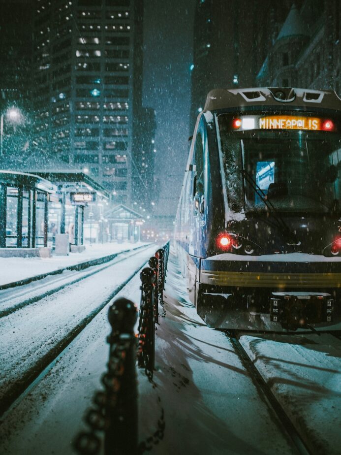 A train pulling into Minneapolis as it snows.