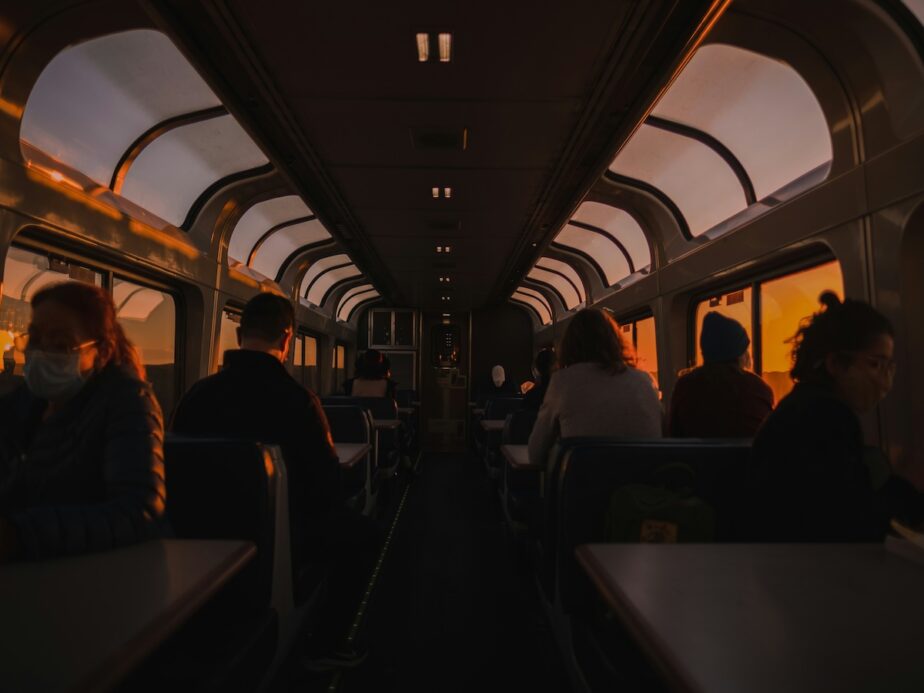 The sun setting while people ride on a train.