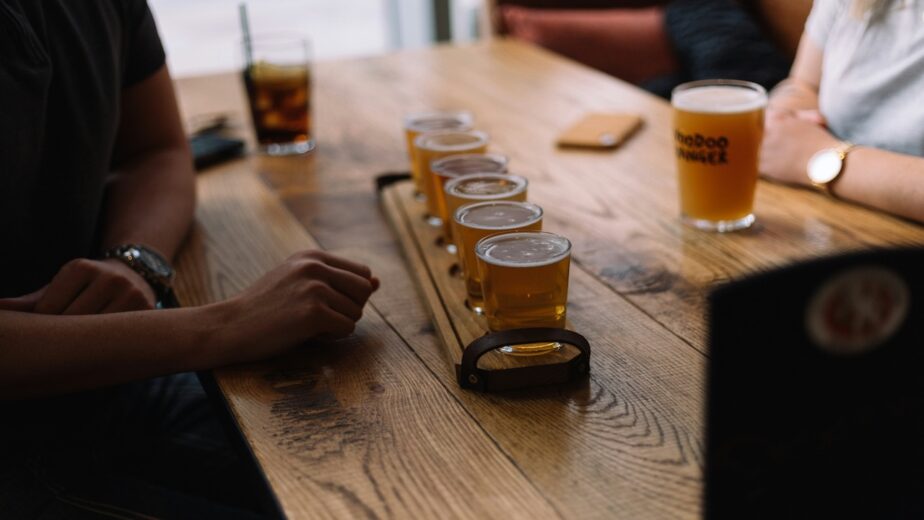 A flight of beer served at a wooden table.