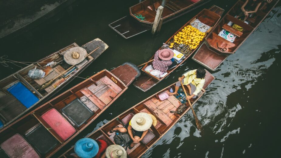 Locals on a boat at the floating market in Thailand.