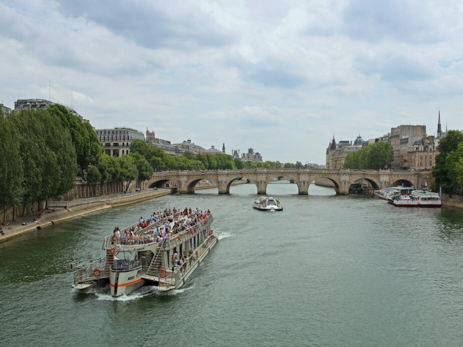 Countless passengers on board a boat along the Seine River.